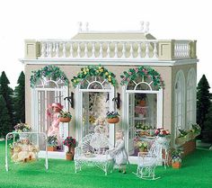 a doll house with furniture and flowers on the lawn