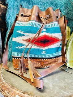 a handbag sitting on top of a table next to a blue and red pillow