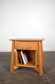 a wooden table with a book shelf on the top and two books in it's drawer