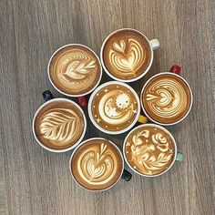 six cups of coffee with designs on them