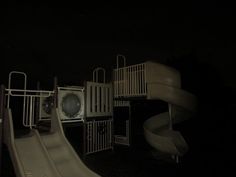 an empty playground at night with a slide in the foreground