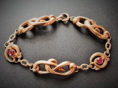 "10k Rose Gold Bracelet,, Gold Ruby Bracelet , Victorian Bracelet, Antique Gold Bracelet, Art Nouveau Bracelet, Love Knot Bracelet, Infinity Bracelet, Yellow Gold Bracelet, Antique Ruby Bracelet, Ruby Bracelet Antique Esemco Art Nouveau Art Deco 10k Rose Gold Love Knot Ruby Bracelet Stunning Esemco Art Nouveau era bracelet. Beautiful infinity or love knot style links crafted in 10k rose gold. Two bezel set 4mm faceted simulated rubies flank the center charm. Weighs about 7.6 grams. Hallmarked 10 Antique Rose Gold Bracelets For Formal Occasions, Hallmarked Rose Gold Bracelets, Victorian Rose Gold Bracelets As Gift, Victorian Rose Gold Bracelets Gift, Victorian Bracelet Antique, Era Bracelet, Love Knot Bracelet, Antique Gold Bracelet, Victorian Bracelet