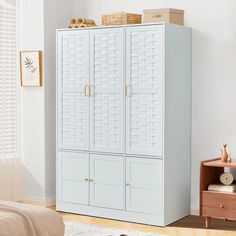 a large white cabinet sitting next to a bed