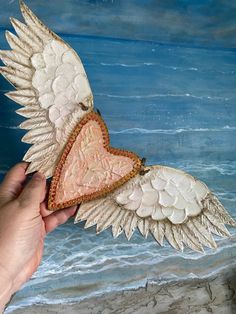 a painting of an angel wing with a heart on it