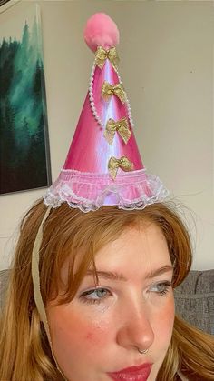 a woman wearing a pink and gold party hat