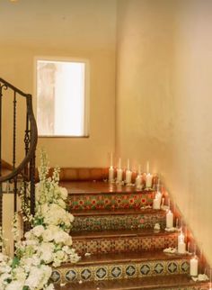 candles and flowers are on the stairs in this house