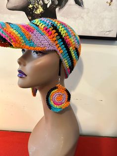 a mannequin head wearing a multicolored hat with earrings on top of it