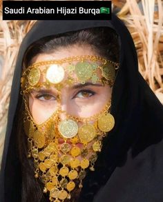 a woman with gold coins on her face wearing a black veil and headdress