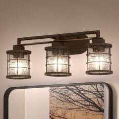 a bathroom vanity with three lights and a mirror