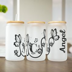 three glass jars sitting on top of a wooden table