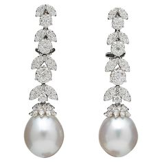 An elegant pair of pearl and diamond dangle earrings. 1.50 carats of white round brilliant cut diamonds set into round and marquise shapes with a pearl drop. 18k white gold Approximately 1.6 inches long A timeless pair of earrings! White Diamond Pearl, Pearl Earrings Long, Art Deco Drop Earrings, White Gold Drop Earrings, Diamond Cluster Earrings, White Pearl Earring, Pearl And Diamond Earrings, Diamond Dangle Earrings, Diamond Chain