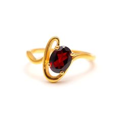 a gold ring with a red stone in the shape of an o - shaped wave