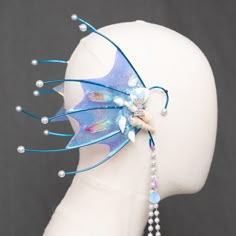 a headpiece made out of plastic and beaded with blue wings, pearls and beads