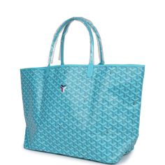 This Limited Edition St. Louis GM tote bag with a large Balise beach towel is in turquoise blue Goyardine coated canvas and chevroches calfskin leather with palladium hardware, contrast stitching, and comes matching detachable button closure wallet.The interior of the tote bag is lined with white canvas.The beach towel included is made of terry cloth and is multicolored with printed floating buoys.Origin: FranceCondition: New and never worn (plastic on handles)Accompanied by: Dustbag, felt, retail tag, removable pouch, towel dustbagMeasurements: tote bag: 15.7" x 13" x 7.8"; beach towel: 36" x 60" Luxury Tote Beach Bag For Travel, Luxury Beach Tote Bag For Travel, Luxury Travel Beach Tote Bag, Luxury Rectangular Beach Bag, Blue Tote Bag For Poolside, Blue Rectangular Beach Bag For Poolside, Blue Summer Bags For Poolside, Luxury Turquoise Travel Bags, Blue Summer Poolside Bags