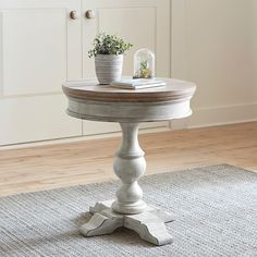 a table with two potted plants on top of it in front of a door