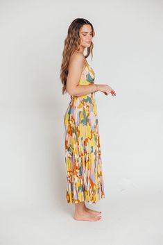 The Blythe Maxi Dress is giving sunshine and ocean breezes, and she's sure to be one of the most colorful pieces in your closet! This stunning maxi dress features a plunging neckline and voluminous skirt, and its abstract floral pattern will give you a gorgeous glow. Imagine wearing this beauty on a beach vacation, at a summer wedding, or on a special date night; you'll be the star of the show wherever you go! FIT: Runs true to size; bodice runs fitted. MODEL: Model is 5’7” / wearing a small. MATERIAL: Self: 100% Polyester; Lining: 100% Polyester. Dry clean only. GARMENT DETAILS: Lightweight sleeveless maxi dress with plisse details. Fitted bodice features a plunging V-neckline, with adjustable straps that crisscross in the back; back is finished with a cut-out detail and tie. Skirt is ver Vibrant V-neck Maxi Dress For Spring, Beach Season Brunch Maxi Dress, Floor-length, Beach Season Floor-length Maxi Dress For Brunch, Floor-length Maxi Dress For Brunch During Beach Season, Summer Midi Dress For Brunch, Floor-length, Summer Floor-length Midi Dress For Brunch, Floor-length Summer Midi Dress For Brunch, Multicolor Maxi Skirt For Summer Vacation, Multicolor Maxi Dress For Garden Party And Beach Season