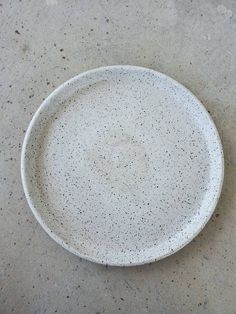 a white plate sitting on top of a cement floor