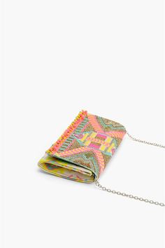 Clutches are all the rage, neons are hotter than ever, so what better way to stay on trend than to combine the two? Our Impala Aztec Clutch is a totally on trend clutch in hot neons with silver details in a super cool flap clutch shape with a totally handy removable cross body strap. Elaborate hand beaded detail adds that effervescent, over-the-top, boho chic detail. The best part about this bag, it can be worn as a crossbody or clutch by changing the strap! Talk about a two for one winner! Whet Trendy Multicolor Clutch For Spring, Trendy Spring Party Clutch, Spring Party Trendy Clutch, Embellished Clutch, Jacquard Fabric, Long Chain, Hand Beading, In Hot, Super Cool