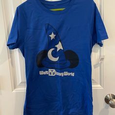 Brand New Never Worn. Size Medium Blue Short Sleeve Themed Tops, Blue Short Sleeve Themed Shirt, Blue Themed Fan Merchandise Tops, Themed Blue Tops For Fan Merchandise, Blue Disney T-shirt For Disney Trips, Disney Graphic Print Blue Shirt, Disney Blue Pre-shrunk Tops, Blue Disney Tops For Disney Trips, Blue Disney Tops For Fan Merchandise