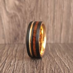 a wooden ring with gold and black inlays