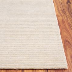 a white rug is laying on the wooden floor