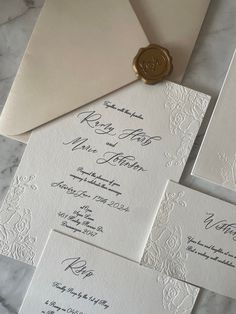 the wedding stationery is laid out on top of each other