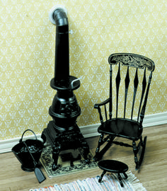 a black rocking chair next to an old fashioned stove and other items on the floor