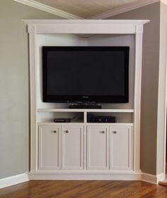 a flat screen tv sitting on top of a white entertainment center