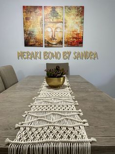 there is a table with a bowl on it and two pictures above it that say merak boho by sandra