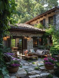 a stone patio with seating and potted plants in the foreground, surrounded by greenery