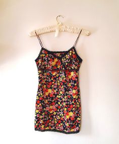 Gorgeous vintage retro summer camisole top ~ in black silky fabric printed with gloriously colourful red, pink and yellow flowers. Crosses at the front with pretty black scallop lace trim around the neckline, woven lace satin ribbon and bow at the side and bows on the split side hems. Spaghetti style straps and no fastenings. Condition Some very light wear to the bows but is in otherwise immaculate condition. Label Unlabelled Material polyester Size Small Measurements taken flat with underbust, Fitted Printed Summer Camisole, Red Retro Spring Tank Top, Retro Red Spring Tank Top, Fitted Multicolor Camisole, Fitted Multicolor Spaghetti Strap Tank Top, Multicolor Fitted Sleeveless Camisole, Vintage Lace Trim Camisole For Spring, Fitted Cotton Camisole With Floral Print, Fitted Floral Print Cotton Camisole