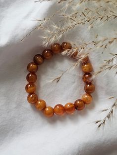 This elastic bracelet is made from unique amber colored beads. Luxury Amber Beaded Bracelets For Gift, Luxury Amber Beaded Bracelets For Gifting, Orange Spiritual Stretch Bracelet Hand-strung, Spiritual Orange Hand-strung Stretch Bracelet, Hand-strung Amber Beaded Bracelets For Gift, Hand-strung Amber Beaded Bracelets As Gift, Amber Hand-strung Beaded Bracelets As Gift, Brown Beaded Bracelets With Round Beads For Gift, Adjustable Amber Bracelets With Large Beads