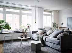 a living room filled with furniture and lots of windows next to a window sill