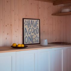 there is a bowl of lemons on the counter in this kitchen with wood paneling