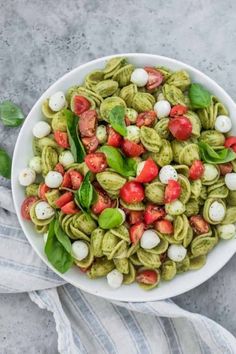 a white bowl filled with pesto pasta salad