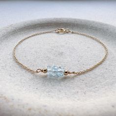 "Genuine blue topaz birthstone beads and two tiny gold filled beads line a simple, minimalist, dainty chain in a choice of gold filled, 14k gold, rose gold filled, or sterling silver chain. Blue Topaz is the December birthstone. It is the perfect everyday bracelet and would make a special gift. We have birthstones for every month and other popular gemstones. * Sizing: 6\"- XXS/XS,  6.5\"/S, 7\"/M, and 7.5\"/L.  Bracelets come in 6\", 6.5\", 7\", and 7.5\". If you need a shorter or longer length please write that length in the 'notes to seller' section during checkout. CRAFTSMANSHIP  Jewelry is handmade by us in our NYC studio. We focus on craftsmanship and quality using only the highest quality materials and handpicked genuine gemstones.  PACKAGING We take pride in creating beautifully pac Delicate Blue Bracelets For Everyday, Minimalist Gold Jewelry With Blue Topaz, Blue Dainty Birthstone Bracelets, Minimalist Blue Topaz Birthstone Jewelry, Minimalist Blue Bracelet With Delicate Chain, Minimalist Everyday Blue Topaz Jewelry, Blue Minimalist 14k Gold Filled Bracelets, Minimalist Blue Topaz Jewelry, Minimalist 14k Gold Filled Bracelets With Birthstone