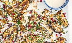 grilled eggplant with pomegranate and nuts on a white platter