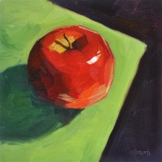 an apple is sitting on a green surface