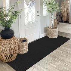 two baskets with plants in them sit on the front door mat next to an entry way