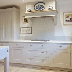 a kitchen with white cabinets and marble counter tops