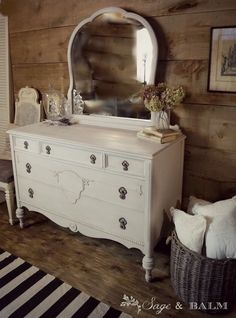 a white dresser and mirror in a room