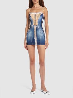 a woman is wearing a denim dress with laces on the bust and side,