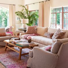 a living room filled with lots of furniture and decor on top of a colorful rug