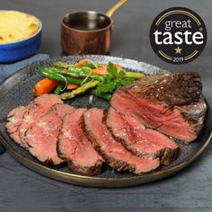 a plate with steak, asparagus and carrots on it