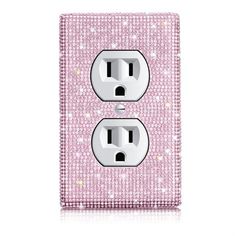 a pink and white light switch cover with some diamonds on it's side, in front of a white background