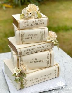 a stack of books sitting on top of a table next to each other with flowers