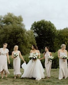 a group of bridesmaids walking in the grass