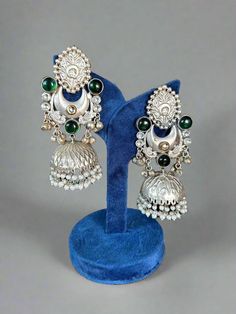 Unleash your Dandiya style with our stunning Silver lookalike Jhumka Earrings! Elevate your outfit with a touch of elegance and add a unique flair to your Navratri look. These exquisite jhumkas will definitely turn heads at garba events. Don't miss out on this must-have accessory! Designer Chandbalis With Tilla For Diwali, Designer Tilla Chandbalis For Diwali, Bollywood Style Chandbalis With Tilla For Designer Wear, Traditional Jhumkas For Designer Festivals, Traditional Meenakari Jhumkas For Designer Wear, Traditional Chandbali Jhumkas For Designer Wear, Designer Tilla Earrings For Diwali, Festive Designer Temple Jewelry Chandbalis, Heavy Bollywood Jhumkas For Designer Wear