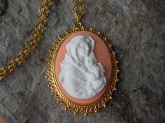 Wonderful look for Easter!!  Beautiful Virgin Mary cradling Baby Jesus cameo necklaces, choose peach, purple or blue!!  The cameos are gorgeous!!!  I do have many other colors and styles, so please do browse, I can make any larger cameo in my shop into this pretty necklace, so browse and message me with a custom order!!!  The pretty setting is classically beautiful, please do see the photo for size!!!  The chain is a matching 24" gold plated rolo link chain with a lobster claw clasp, if you woul Vintage Peach Necklace As Gift, Vintage Peach Necklace As A Gift, Vintage Peach Necklace For Gift, Pink Cameo Necklace For Gifts, Vintage Peach Jewelry For Gifts, Blue Virgin Mary, Mary And Baby Jesus, Easter Jewelry, Easter Religious