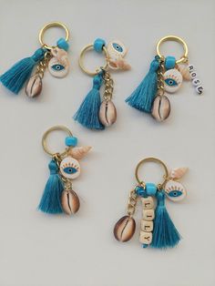 four keychains with seashells, shells and tassels on them